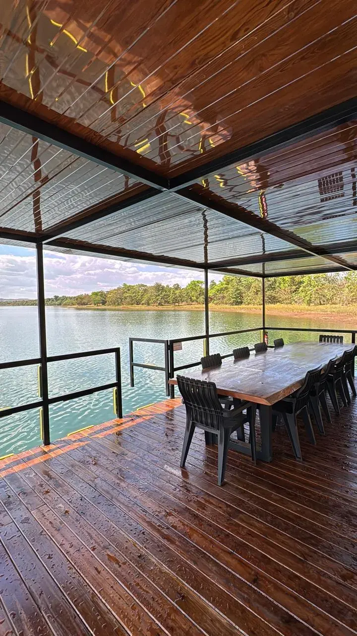 Plataforma flutuante coberta com mesa e cadeiras sobre lago