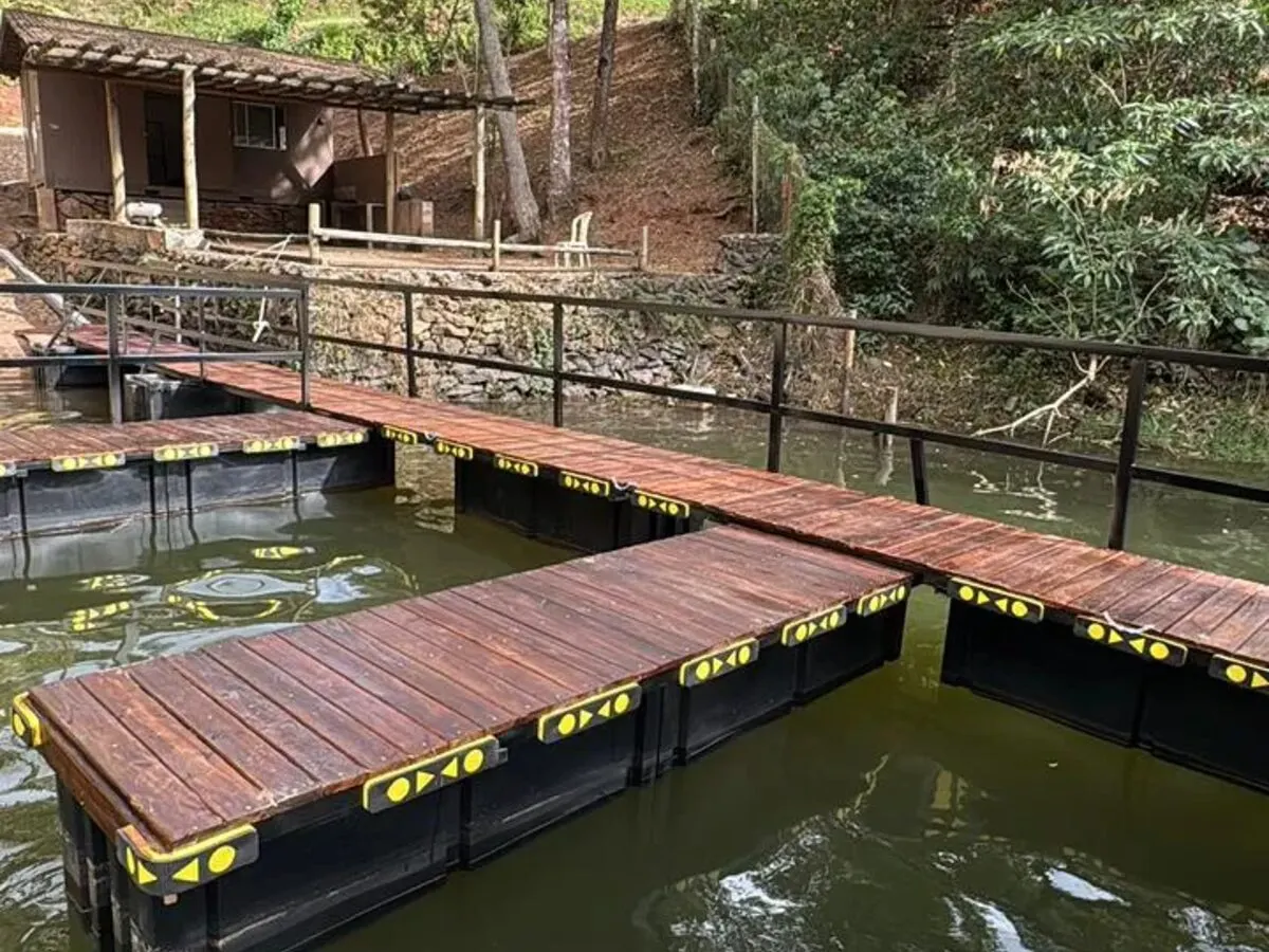 Deck flutuante em lago com mata ao redor